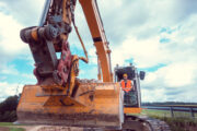 Construction worker on excavator planning the work to be done on the site