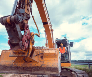 Construction worker on excavator planning the work to be done on the site